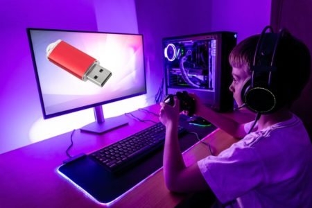 Un garçon jouant sur un PC avec une clé USB affichée sur l'écran.