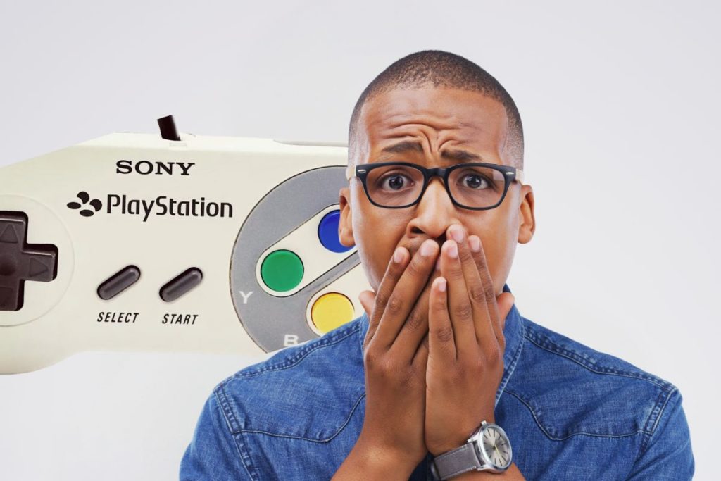 Homme surpris devant une ancienne manette de PlayStation de Sony.