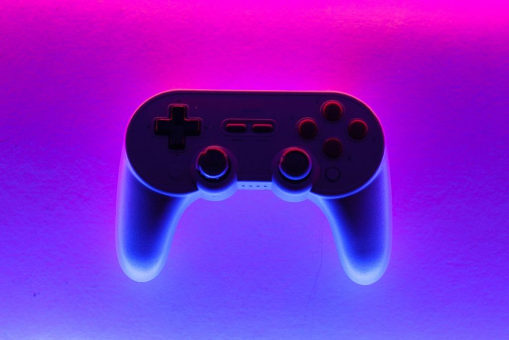 Une manette de jeu rétroéclairée en rose et bleu